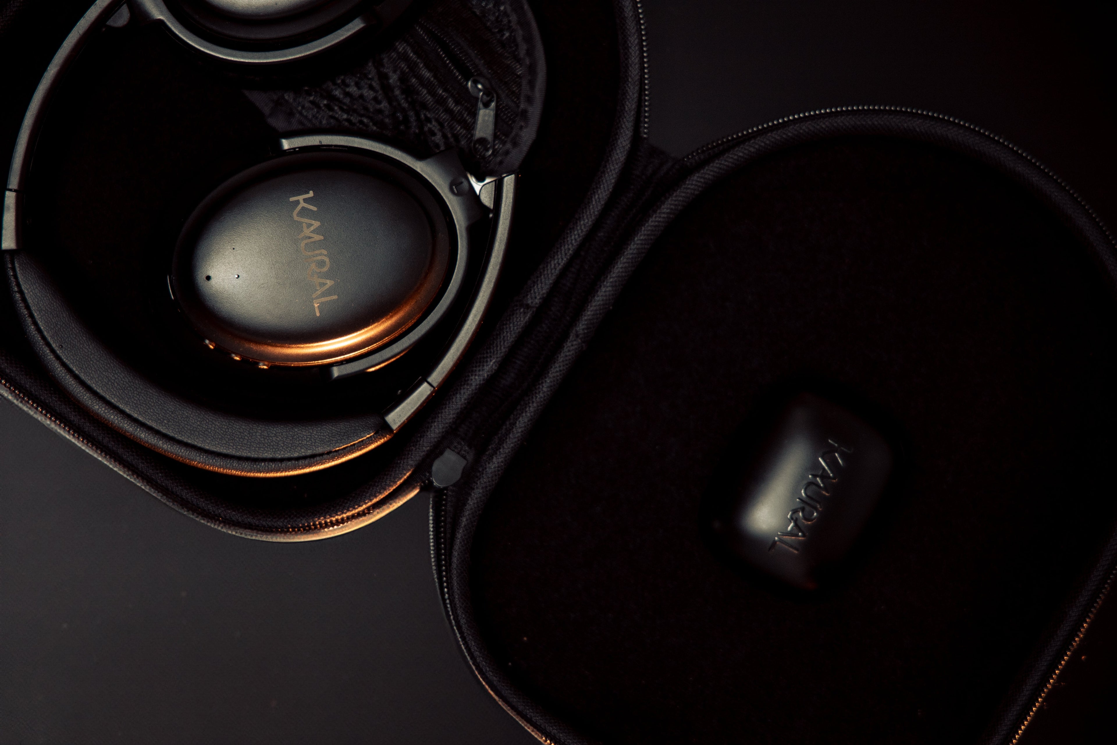 Pair of headphones with 'kaural' branding in a black case on a dark background